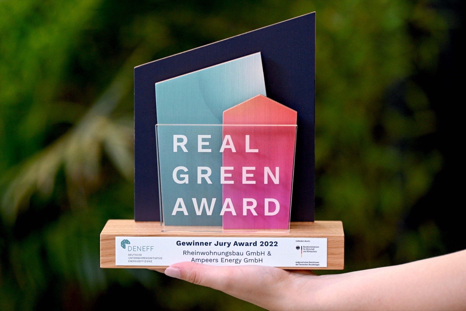 Trophäe des RealGreen Award 2022 für die Rheinwohnungsbau und Ampeers Energy