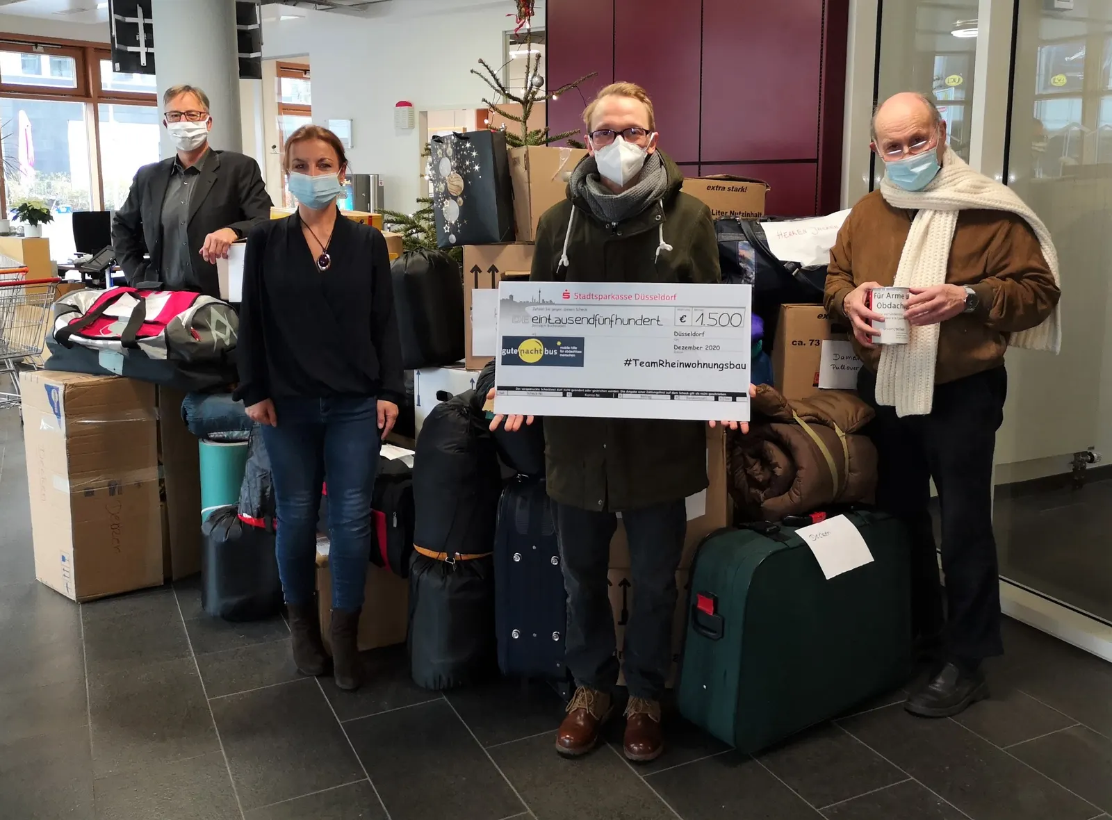 Mitarbeitende der Rheinwohnungsbau übergeben Spenden für den gutenachtbus